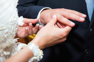 Close up bride put the wedding ring on groom