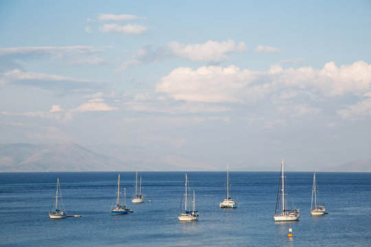Blue water and sky background on the ocean with sailing boats.
