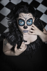 Sugar Skull mit Haarschmuck auf Hintergrund, Frau sitzend