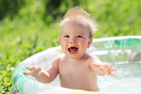 funny baby splash in the pool outdoors