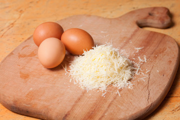 Grated parmesan and eggs on table