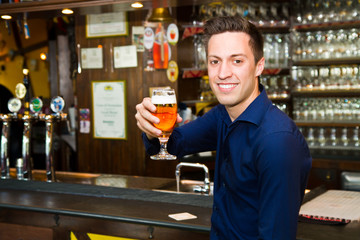  young man holding a beer and looking at camera 