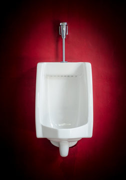 White urinal on red wall with vignett