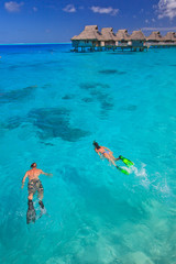 Couple snorkeling in the blue lagoon, Bora Bora, South Pacific - obrazy, fototapety, plakaty