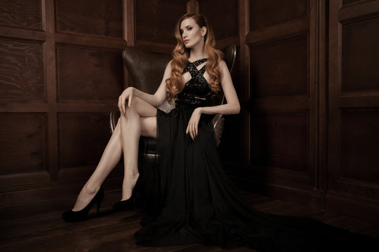 The image of a beautiful luxurious woman sitting on a leather vi