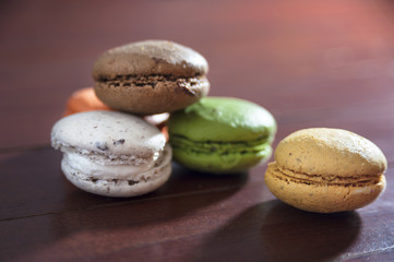 Fototapeta na wymiar French colorful macarons on a wooden floor, morning snack