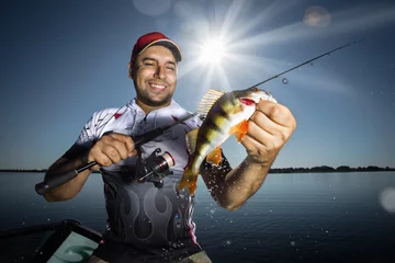 Zelfklevend Fotobehang Happy angler with perch fishing trophy © vitaliy_melnik
