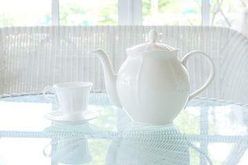 Cup of tea with teapot on table