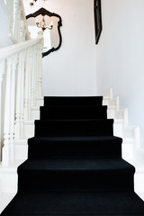 Modern staircase of a classic building with black carpet
