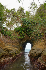 Natural tunnel in the rock dug by the sea