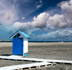 Wooden colorful cabin on a desert beach