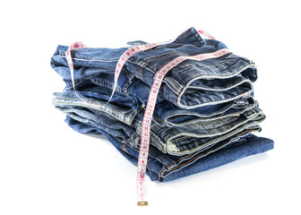 heap of jeans trousers with tape measure