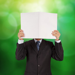 businessman with open book over abstract light background as co