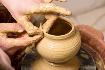 hands of a potter, creating an earthen jar