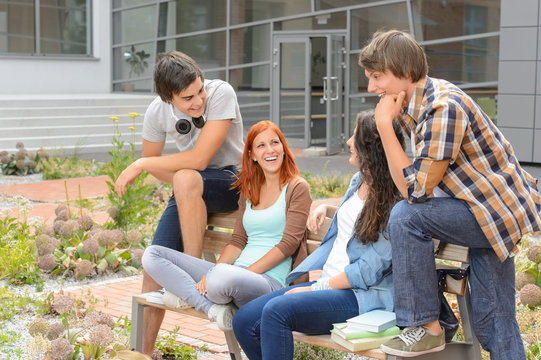 Student friends sitting outside campus laughing