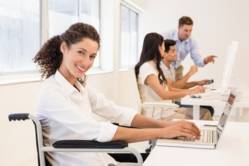 Casual businesswoman in wheelchair smiling at camera