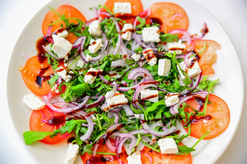 fresh salad with tomatoes arugula red onion and feta cheese