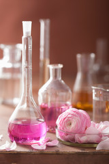 Obraz na płótnie Canvas alchemy and aromatherapy set with ranunculus flowers and flasks