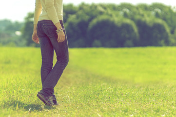 background girl standing half-turned her back on the park lawn a