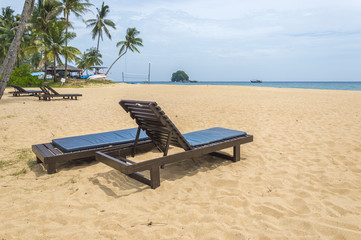 Wooden lounge with clean sand at tropical island