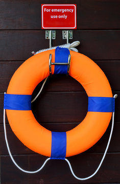 Red life buoy on a wooden wall
