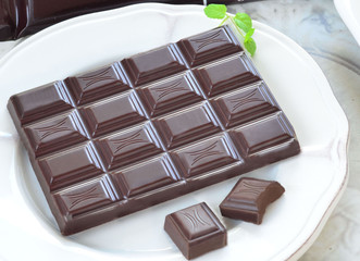 tabliczka ciemnej czekolady na białym talerzyku