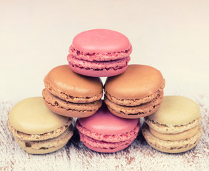Colorful fresh delicious macaroons on vintage wooden background