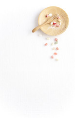 many candy in wooden dish on white fabric