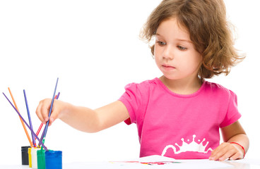 Little girl is painting with gouache