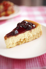 close up blueberry cheese cake and blueberry sauce in white dish