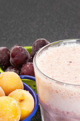 Cherry and plum in a colander and a milkshake