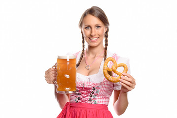 Lächelnde Frau im Dirndl mit einem Bier und Brezel