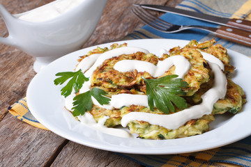Zucchini Pancakes with sour cream close-up