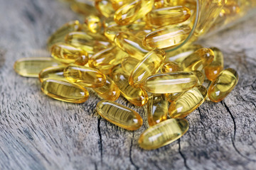 Cod liver oil omega 3 gel capsules isolated on wooden background