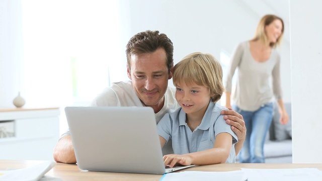 Parents with children using laptop computer at home