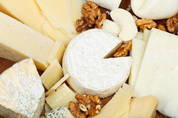 assortment of cheeses on wooden plate