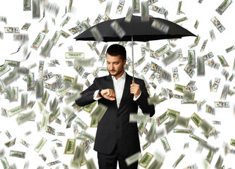 man under money rain looking at watch
