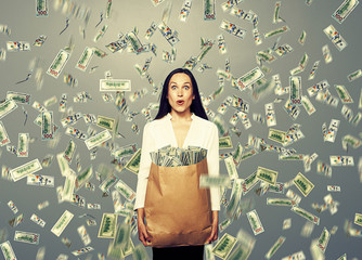 surprised businesswoman holding money