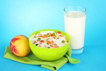 tasty dieting food, fruits and glass of milk, on blue