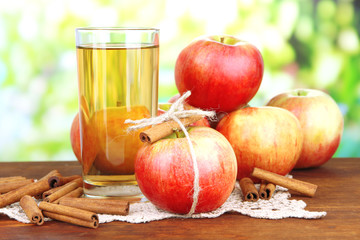 Ripe apples with with cinnamon sticks and glass of  apple drink