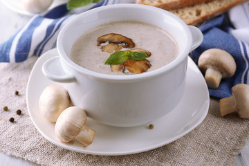 Mushroom soup in white pots, on napkin,  on wooden background