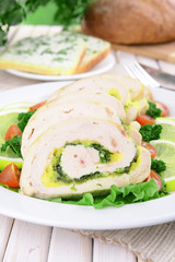 Delicious chicken roll on plate on table close-up