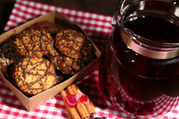 Jar of herbal tea and cookies on table