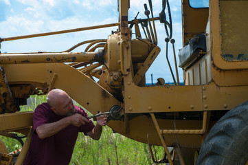 Man using pliers to work on electrical system of bulldozer