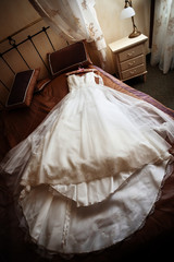Obraz na płótnie Canvas Wedding dress lying on a bed