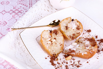 Baked pears with syrup on plate, on bright background