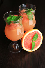 Grapefruit cocktail in glasses on wooden background