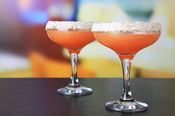 Grapefruit cocktail in glasses on bright background