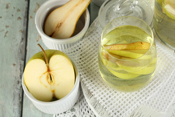 Sangria drink in glass and jar on wooden background