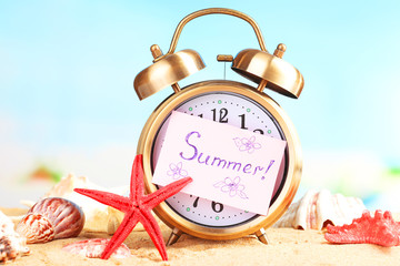 Summertime. Old clock on sand